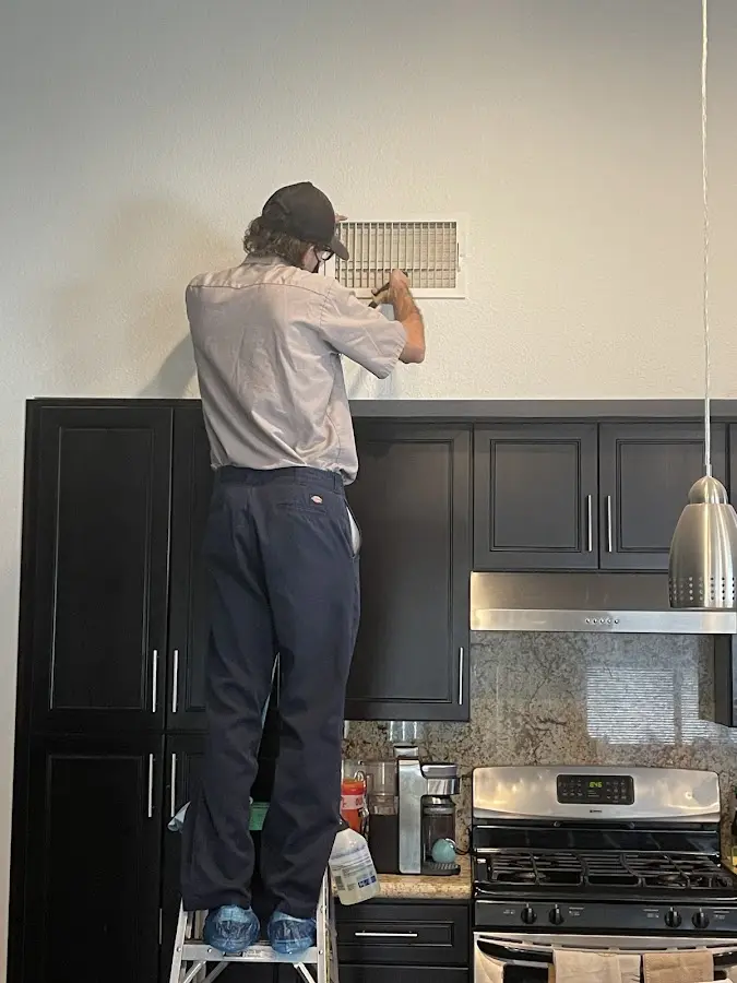 Technician inspecting an air vent during HVAC service in Blue Island